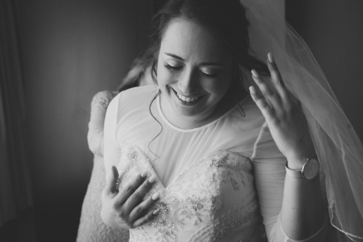 black and white photo of the bride getting put into her wedding dress