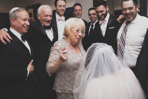 Grandmother and family dances around the bride during ketubah signing ceremony and everyone is smiling