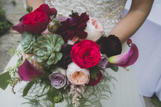 bride holds her bouquet filled with bold and bright colors and different flowers like pinks, magentas, purples and succulents