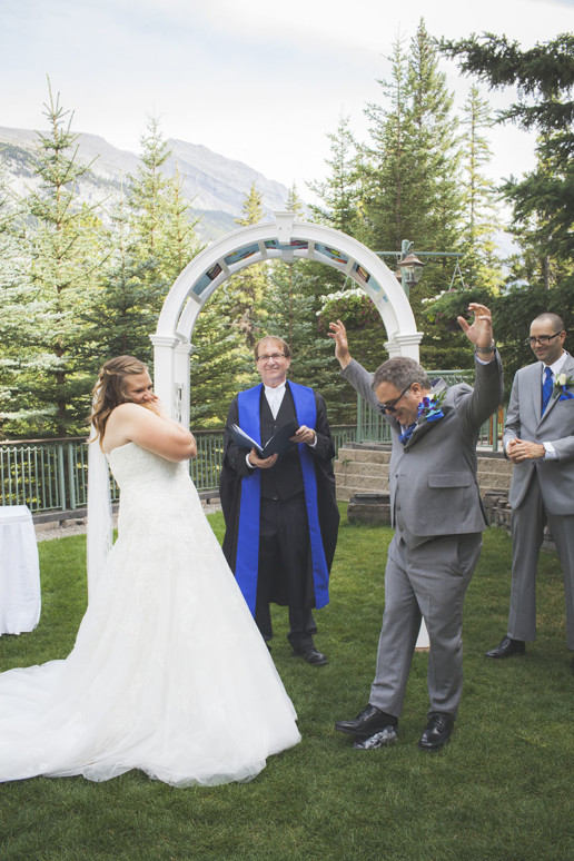 A man celebrate breaking the glass during an outdoor wedding ceremony at a destination wedding in Banff Alberta at the Rimrock Resort Hotel