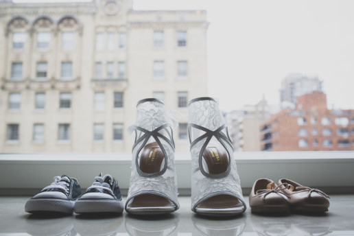 detail photo of the bride's shoes and of her twin babies shoes of ballet flats and baby converse sneakers