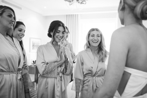 reveal of bride in her wedding dress to bridesmaids and their reaction while wearing matching bridesmaids robes