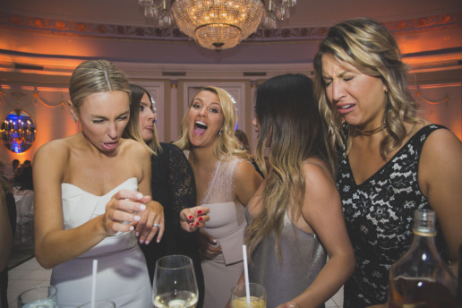Bride and friends react to doing shots at the bar at the party in the Oval Room