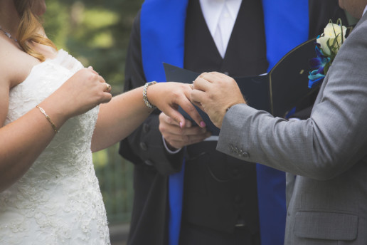 Groom places ring on bride's finger during ceremony