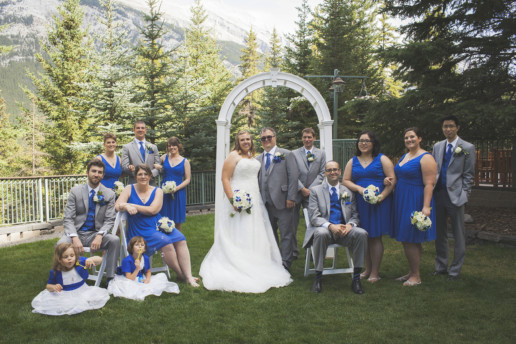 Bridal party pose together at the Rimrock Resort and Hotel on the outside terrace in Banff