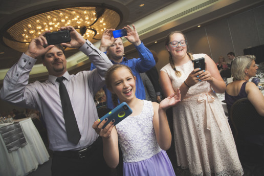 guests take photos with their cell phones at the reception