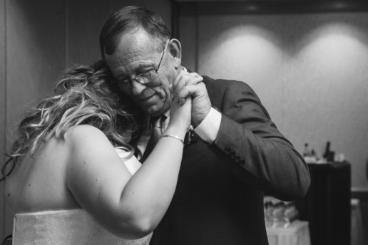 black and white photo of father and daghter holding each other during parent dance