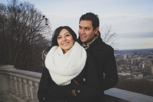 while on their engagement photo shoot a man and woman hold each other at the lookout atop mount-royal in montreal
