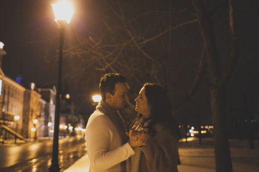 while doing their engagement shoot a man and woman dance together under the street lamp in old montreal