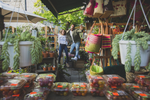 Jumping for joy in the flower market for their Montreal engagement shoot by Studio Baron Photo