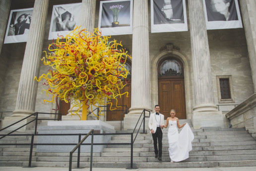 Couple walk down the steps of the Montreal Museum of Fine Arts on their wedding day