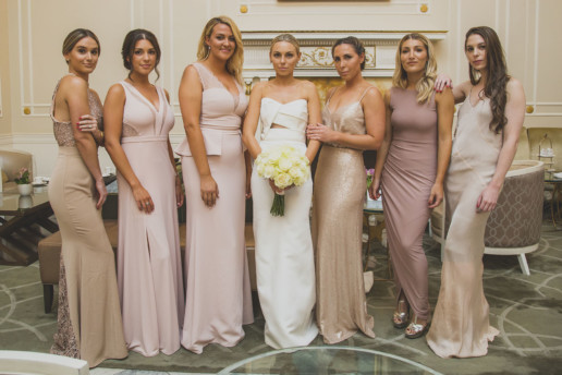 bride and bridesmaids in dresses of shades of blush, pink and gold in the palm court of the Ritz-Carlton Montreal