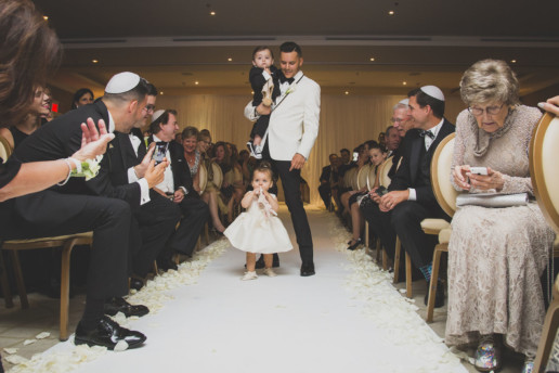 Groom walks down the aisle for his wedding ceremony with his twin children in the Gold room at the Ritz-Carlton Montreal