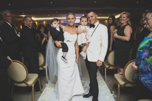 a couple and their twin children walk down the aisle following tehir wedding ceremony in the Gold Room at the Ritz-Carlton Montreal