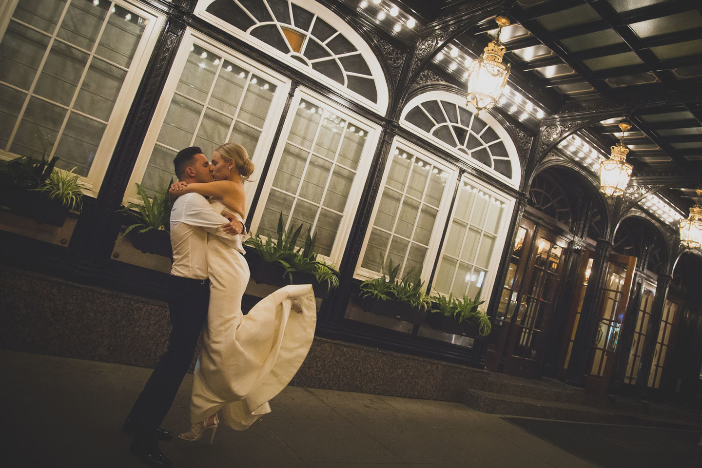 Couple embrace at night in front of the main entrance on Sherbrooke street ouest of the Ritz-Carlton Montreal