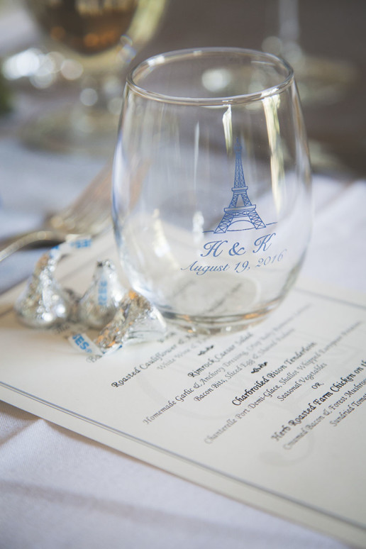 detail photo of the glass with the couple's logo on it with the menu for the reception