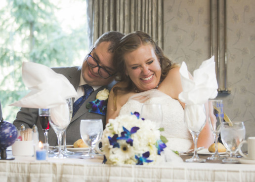 Bride and groom cuddle and smile together during the reception at the Rimrock resort and hotel in Banff