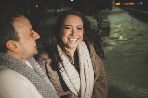 for their engagement shoot a man and a woman share a laugh in the old port of montreal at night